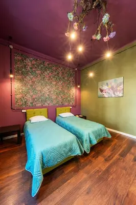 two beds in a room with a painting on the wall at Guesthouse32 in Sofia