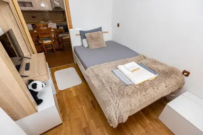 a small bedroom with a bed and a table at Апартамент “Djanina 2” in Sandanski