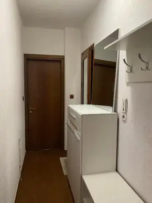 a white refrigerator in a kitchen with a door at Апартамент “Djanina 2” in Sandanski