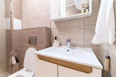 a bathroom with a white sink and a toilet at Stylish One-Bedroom Apartment in Plovdiv