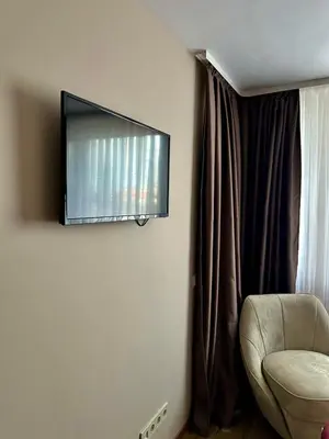 a flat screen tv hanging on a wall next to a chair at CENTER Elegant Living in Sofia