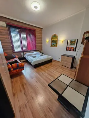 a bedroom with a bed and a table in it at Central 1-BR Apartment in Sofia