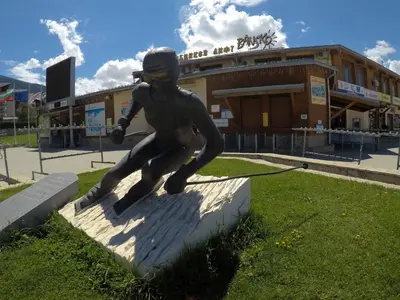 a statue of a boy is in front of a building at Monastery Apartment C39 in Bansko