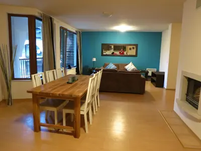 a living room with a wooden table and a couch at Monastery Apartment C39 in Bansko
