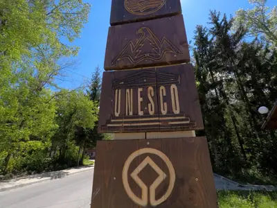 a wooden sign that says universeo on a pole at Monastery Apartment C39 in Bansko