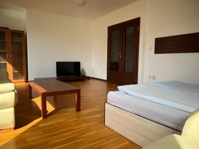 a bedroom with a bed and a desk and a television at Вила и тенис комплекс ,,Синьото