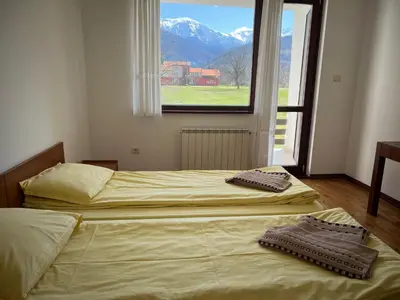 two twin beds in a room with a window at Вила и тенис комплекс ,,Синьото