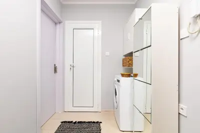 a white kitchen with a refrigerator and a door at Central apt 'SELIN' Walking distance to center in Plovdiv