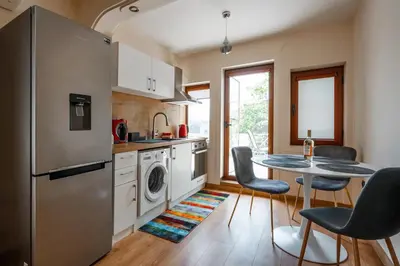 a kitchen with a refrigerator and a table and chairs at 2-Bedroom Flat - Sunny Balcony in Plovdiv