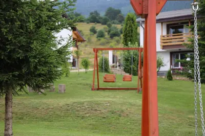 a swing set in the yard of a house at ЕДЕЛВАЙС Сърница in Sarnitsa