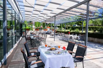 a dining room with tables and chairs and a glass ceiling at Local Stay Villas in Bansko