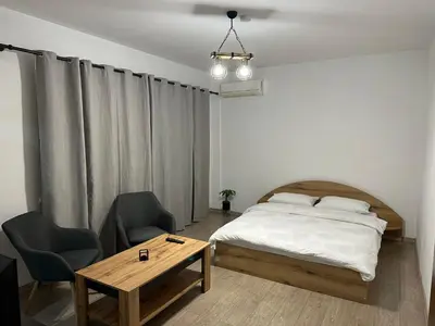 a bedroom with a bed and a table and chairs at Апартамент Бояна in Plovdiv