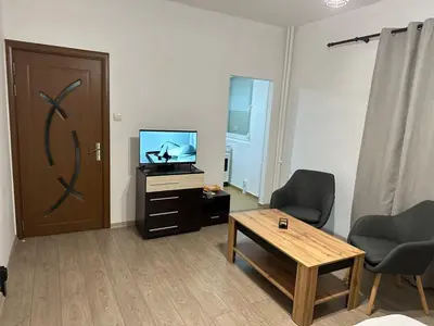 a living room with a tv and a table and a door at Апартамент Бояна in Plovdiv