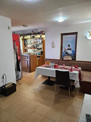a dining room with a table and a kitchen at Aparthotel Raikov Ski Lodge in Pamporovo