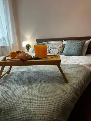 a tray with bread and drinks on a bed at Casa Rea - Comfortable Stay with Free Parking in Sofia