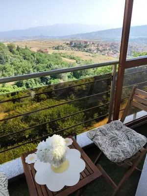 a table and chairs on a balcony with a view at Sunny Hill Sandanski in Sandanski