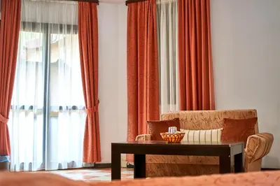 a living room with a chair and a table at Вълеви Къщи in Chiflik
