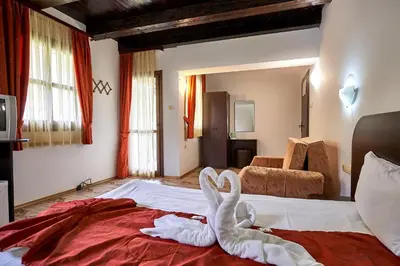 a bedroom with a bed with a towel animal on it at Вълеви Къщи in Chiflik