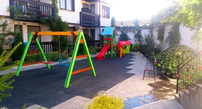 a playground with colorful play equipment in a yard at Hotel Zara in Bansko