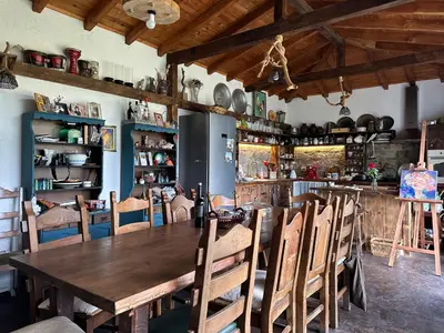 a dining room with a wooden table and chairs at Guest House Opa in Smolyan