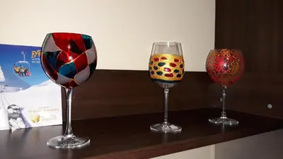 three wine glasses sitting on top of a counter at Ski Lift Apartment in Bansko in Bansko
