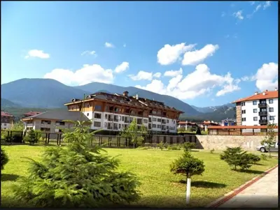 a large apartment building with mountains in the background at Ski Lift Apartment in Bansko in Bansko