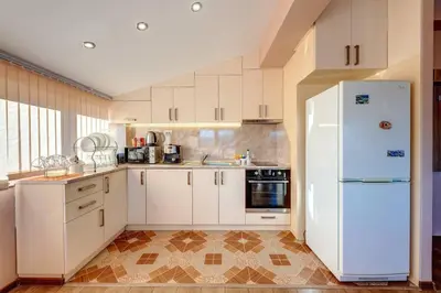 a kitchen with white cabinets and a white refrigerator at Apartment Yana- The Amazing View in Smolyan
