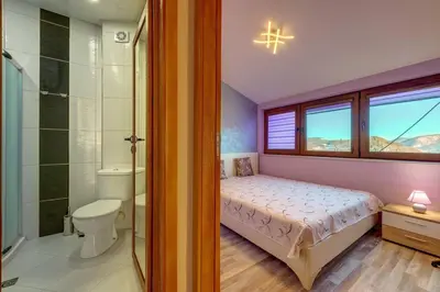 a bedroom with a bed and a bathroom with a shower at Apartment Yana- The Amazing View in Smolyan