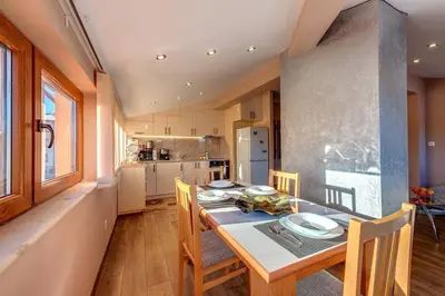 a dining room with a table and chairs in a kitchen at Apartment Yana- The Amazing View in Smolyan