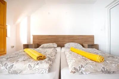 two beds in a room with two yellow pillows at Nova Guesthouse - Private En-Suite Rooms I Sofia Center I Self Check-In in Sofia