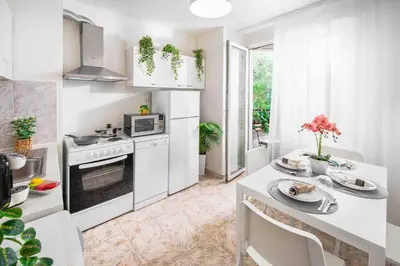 a kitchen with white appliances and a table with plates at Spacious and relaxing in Sofia