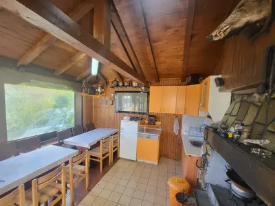 a kitchen with tables and chairs in a cabin at Вила Беевски in Gela