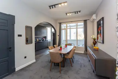 a kitchen and dining room with a table and chairs at Urban Elegance Apartment in Sofia