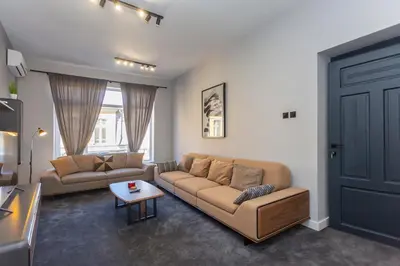 a living room with a couch and a table at Urban Elegance Apartment in Sofia