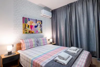 a bedroom with a bed with two towels on it at Best Guest 2 Apartments in Plovdiv