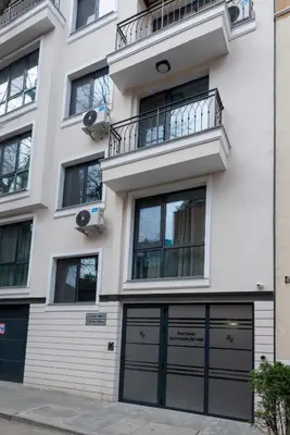 a white building with two garage doors and a balcony at Best Guest 2 Apartments in Plovdiv