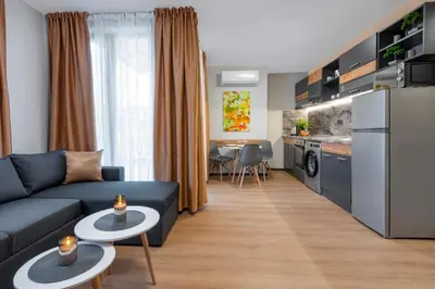 a living room with a blue couch and a kitchen at Best Guest 2 Apartments in Plovdiv