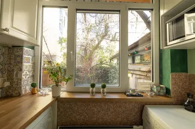 a kitchen with a window with two potted plants on a counter at ArtE Vitosha Blvd in Sofia