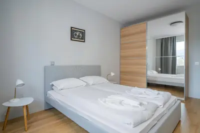 a white bed in a bedroom with a mirror at Modern and Central 1BD Flat with Balcony by Flat Mаnager in Sofia