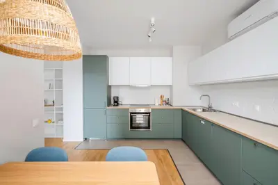 a kitchen with blue cabinets and a table with blue chairs at Modern and Central 1BD Flat with Balcony by Flat Mаnager in Sofia
