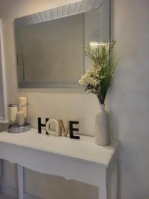 a white table with a mirror and a vase with flowers at Luxury apartment in Teteven