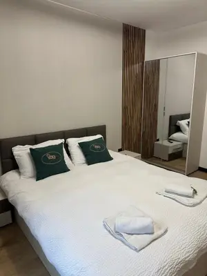 a bedroom with a large bed with towels on it at MonarX Suites in Bansko