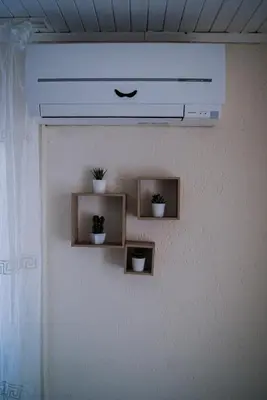 a wall with three shelves with potted plants on it at NIKI Apart in Sofia