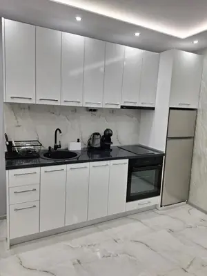 a white kitchen with white cabinets and a sink at Sandanski park view in Sandanski