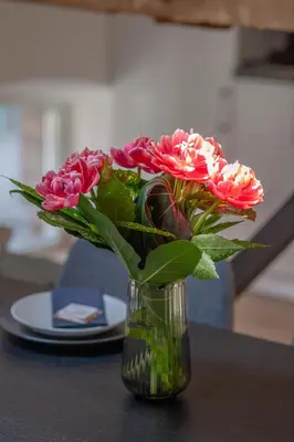 a vase filled with pink flowers on a table at Ruby Red House in Sofia