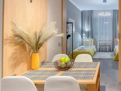 a dining room with a table with a vase of fruit at Stylish City Center Apartment by NDK in Sofia