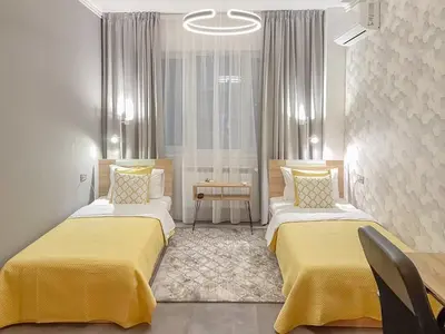 a hotel room with two beds with yellow sheets at Stylish City Center Apartment by NDK in Sofia
