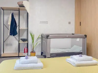 a room with a bed with two towels on a table at Stylish City Center Apartment by NDK in Sofia
