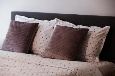 a bed with four pillows on top of it at Alexandra Family Estate in Samoranovo