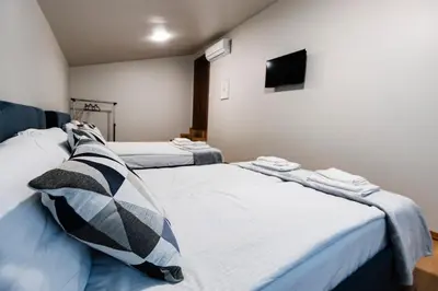 two beds in a room with a tv on the wall at Alexandra Family Estate in Samoranovo